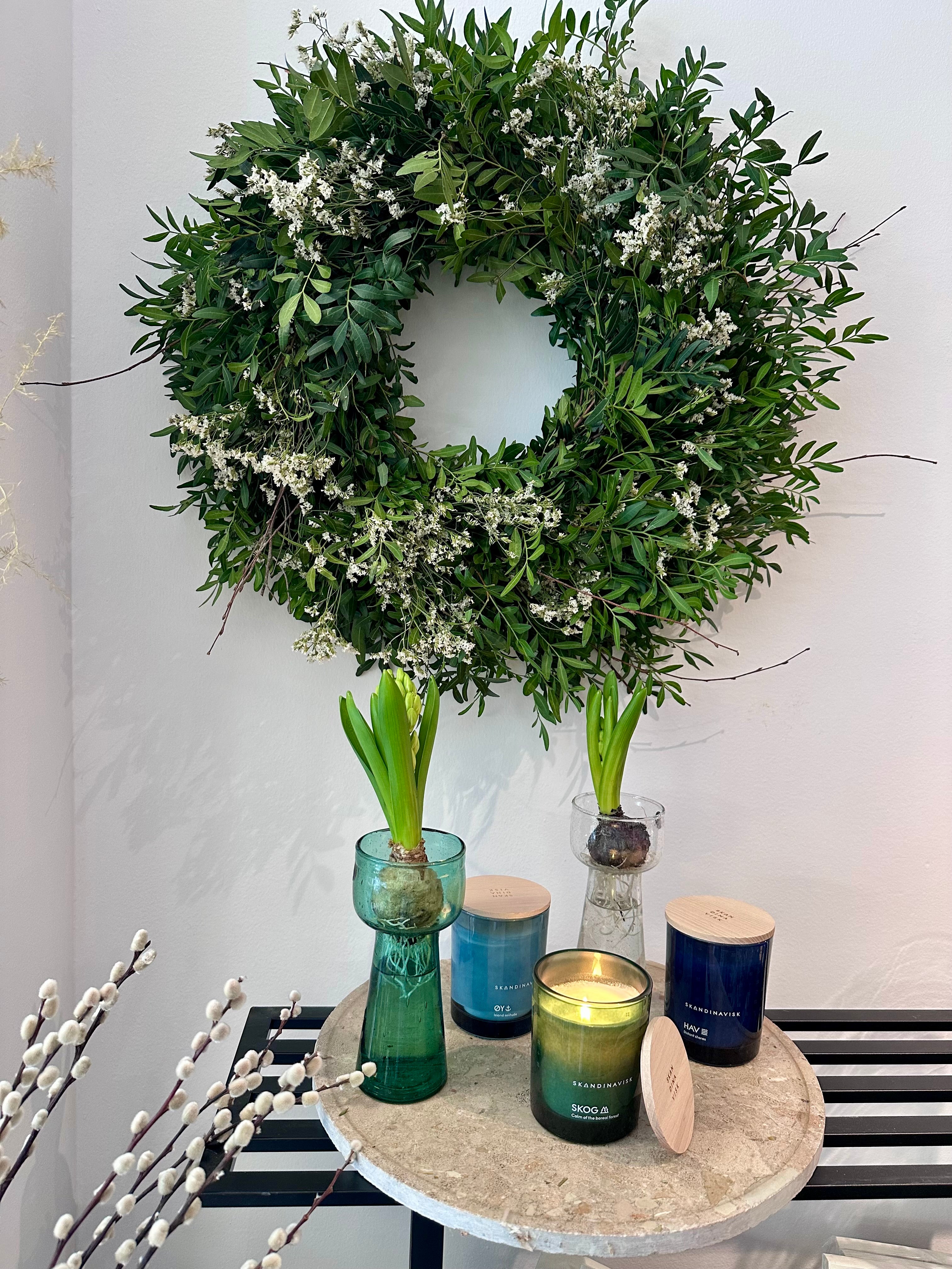 Vista lateral de corona natural con follaje verde y flores blancas