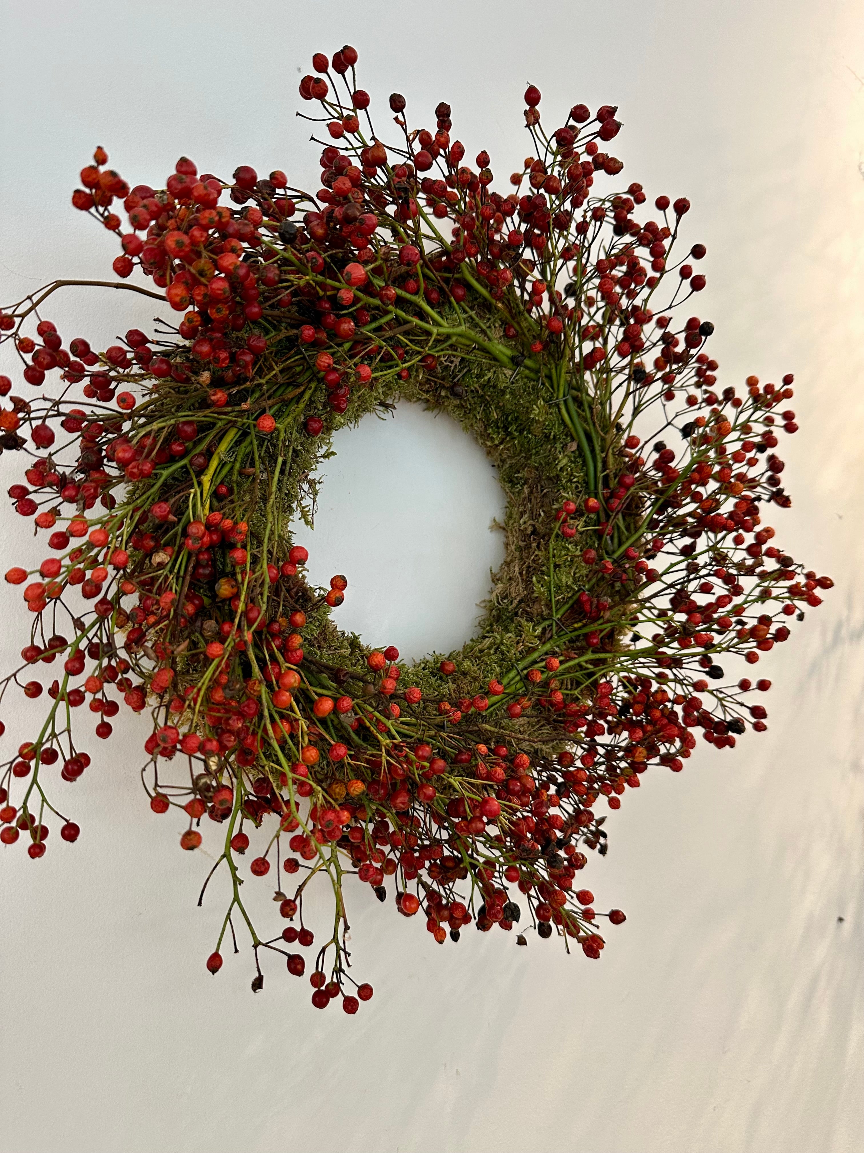 Corona de musgo con frutos rojos