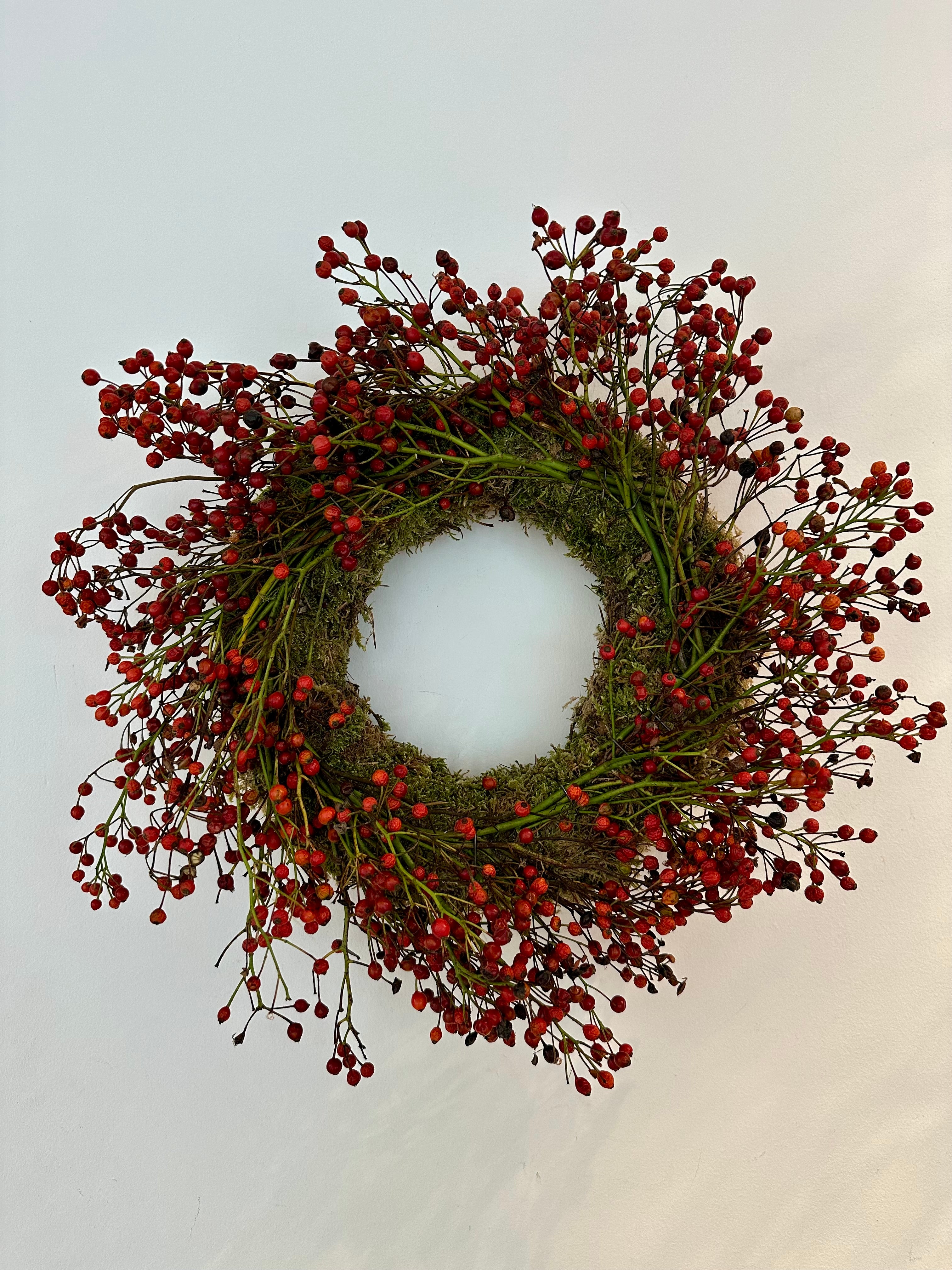 Corona de musgo con frutos rojos