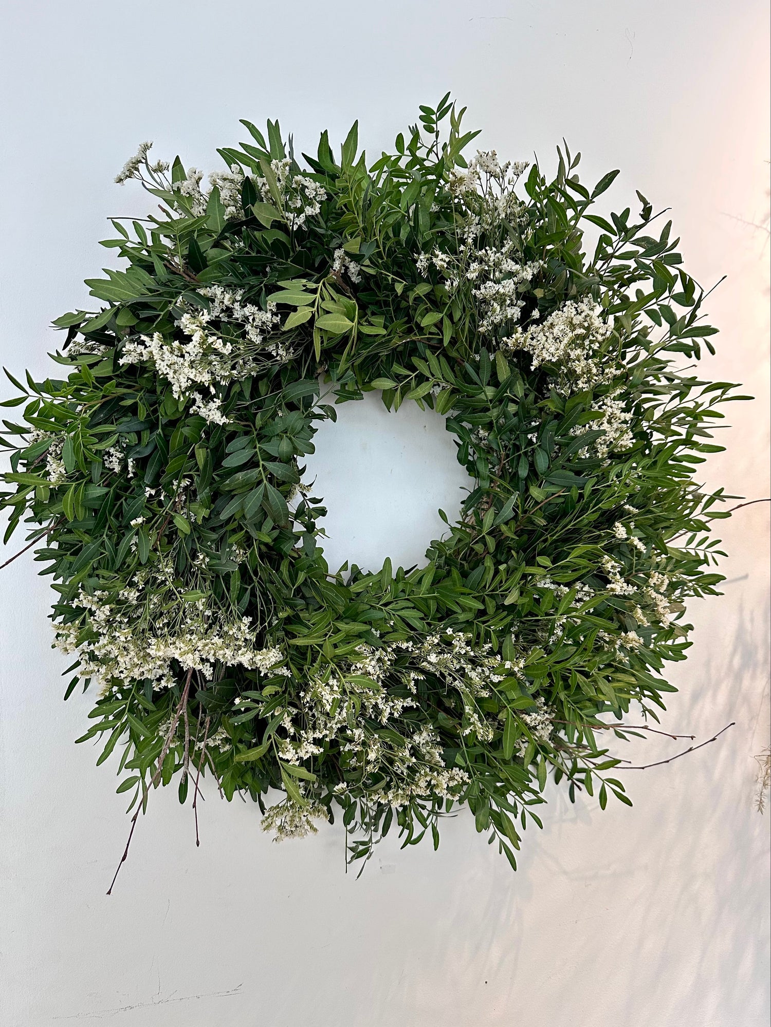 Detalle de flores blancas silvestres sobre corona verde