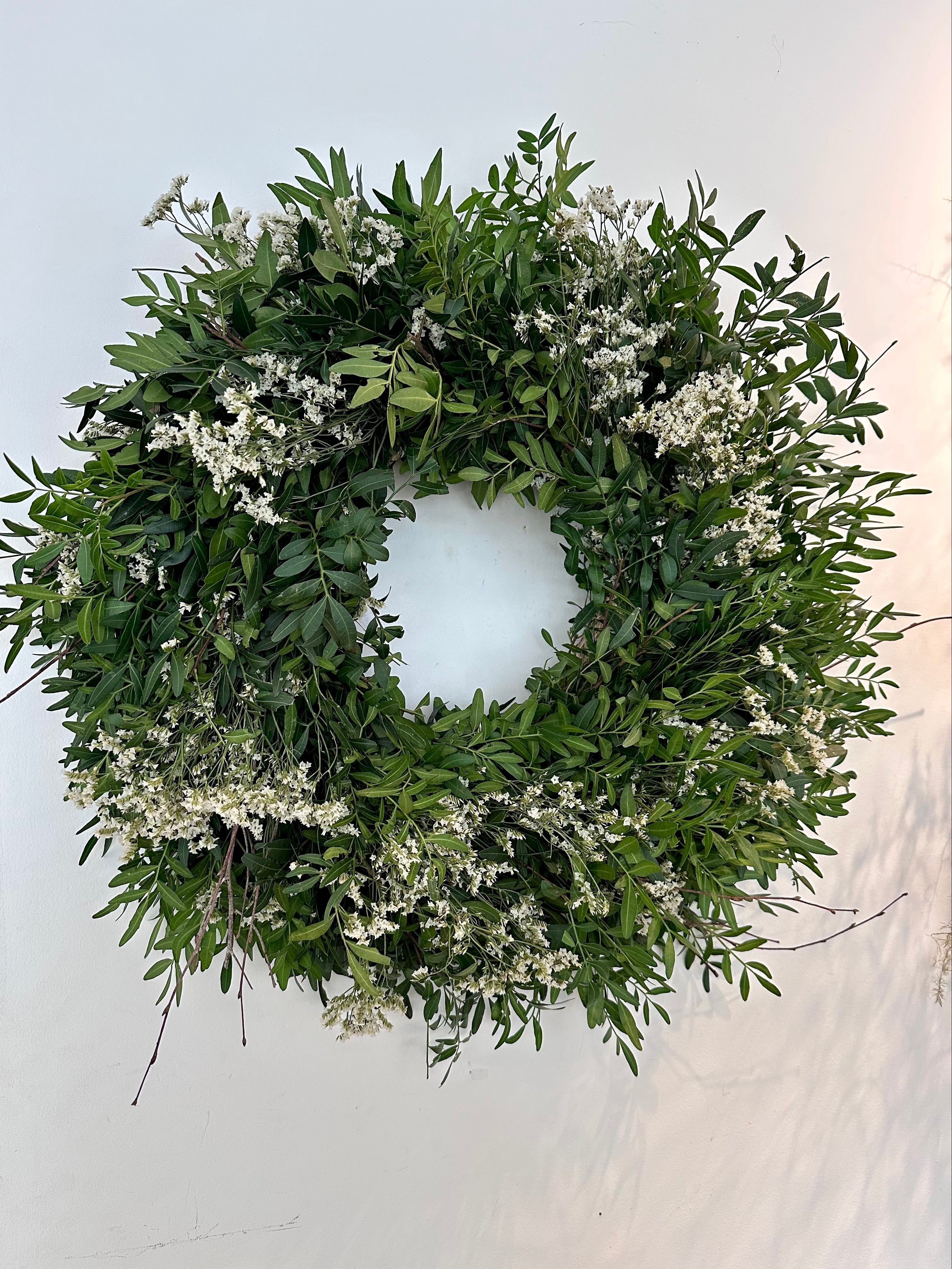 Detalle de flores blancas silvestres sobre corona verde