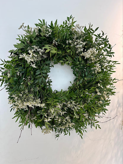 Detalle de flores blancas silvestres sobre corona verde