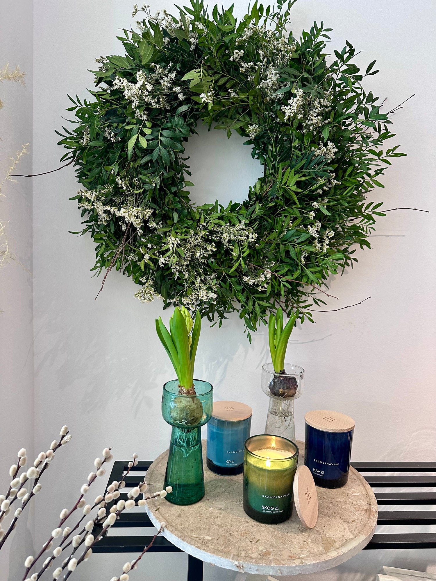 Vista lateral de corona natural con follaje verde y flores blancas