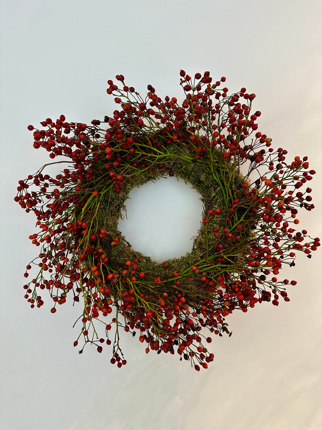 Corona de musgo con frutos rojos